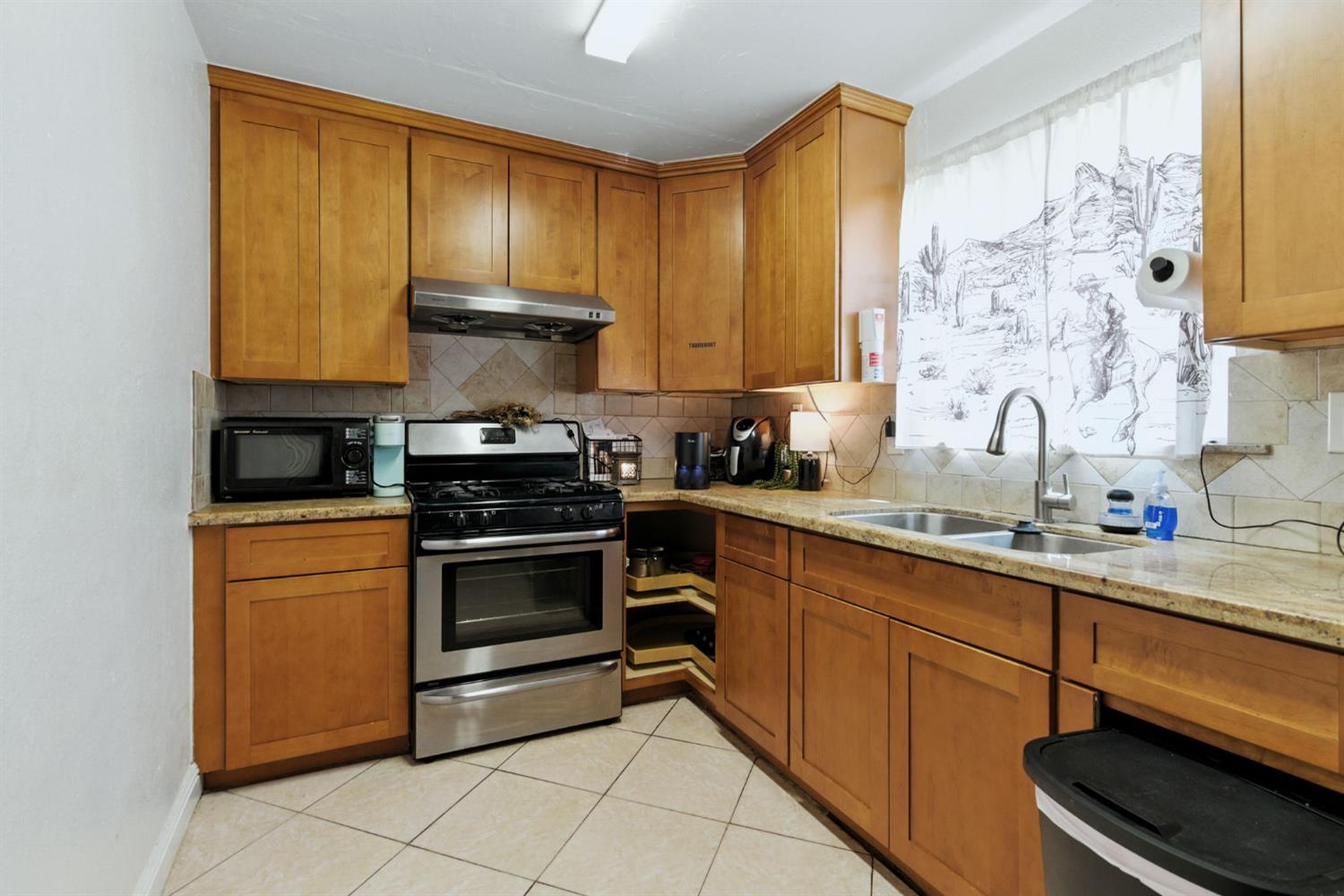 312 West Main Street Turlock, CA 95380 - Photo 54 of 84 a kitchen with stainless steel appliances granite countertop a stove a sink and a microwave