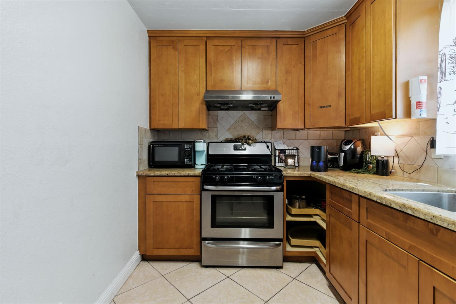 312 West Main Street Turlock, CA 95380 - Photo 55 of 84 a kitchen with stainless steel appliances granite countertop a stove a sink and a microwave