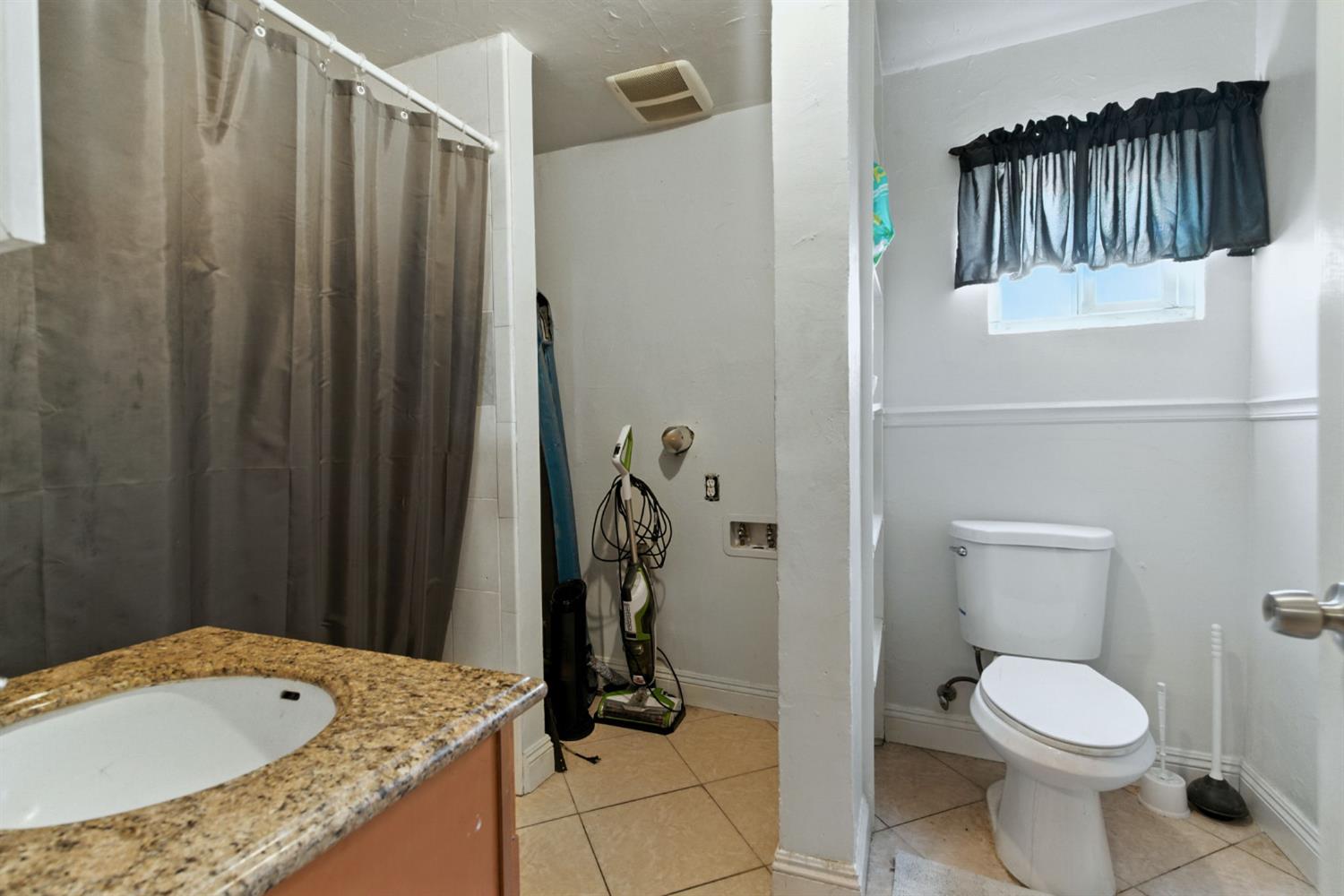 312 West Main Street Turlock, CA 95380 - Photo 57 of 84 a bathroom with a granite countertop sink and a toilet