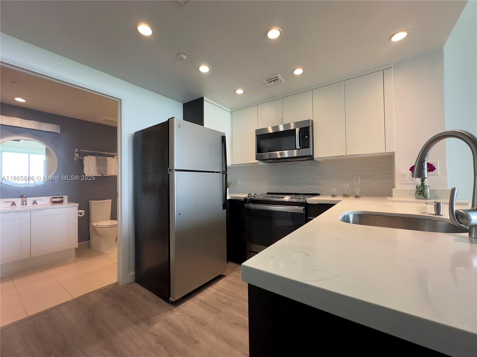 2889 McFarlane Road, Unit 1406 Miami, FL 33133 - Photo 11 of 23 a kitchen with stainless steel appliances a refrigerator and a sink
