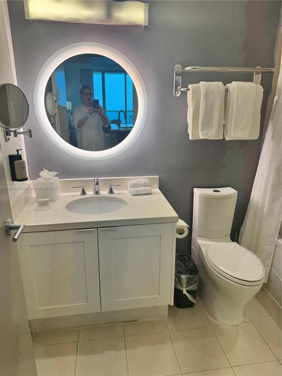 2889 McFarlane Road, Unit 1406 Miami, FL 33133 - Photo 14 of 23 a bathroom with a toilet sink and mirror