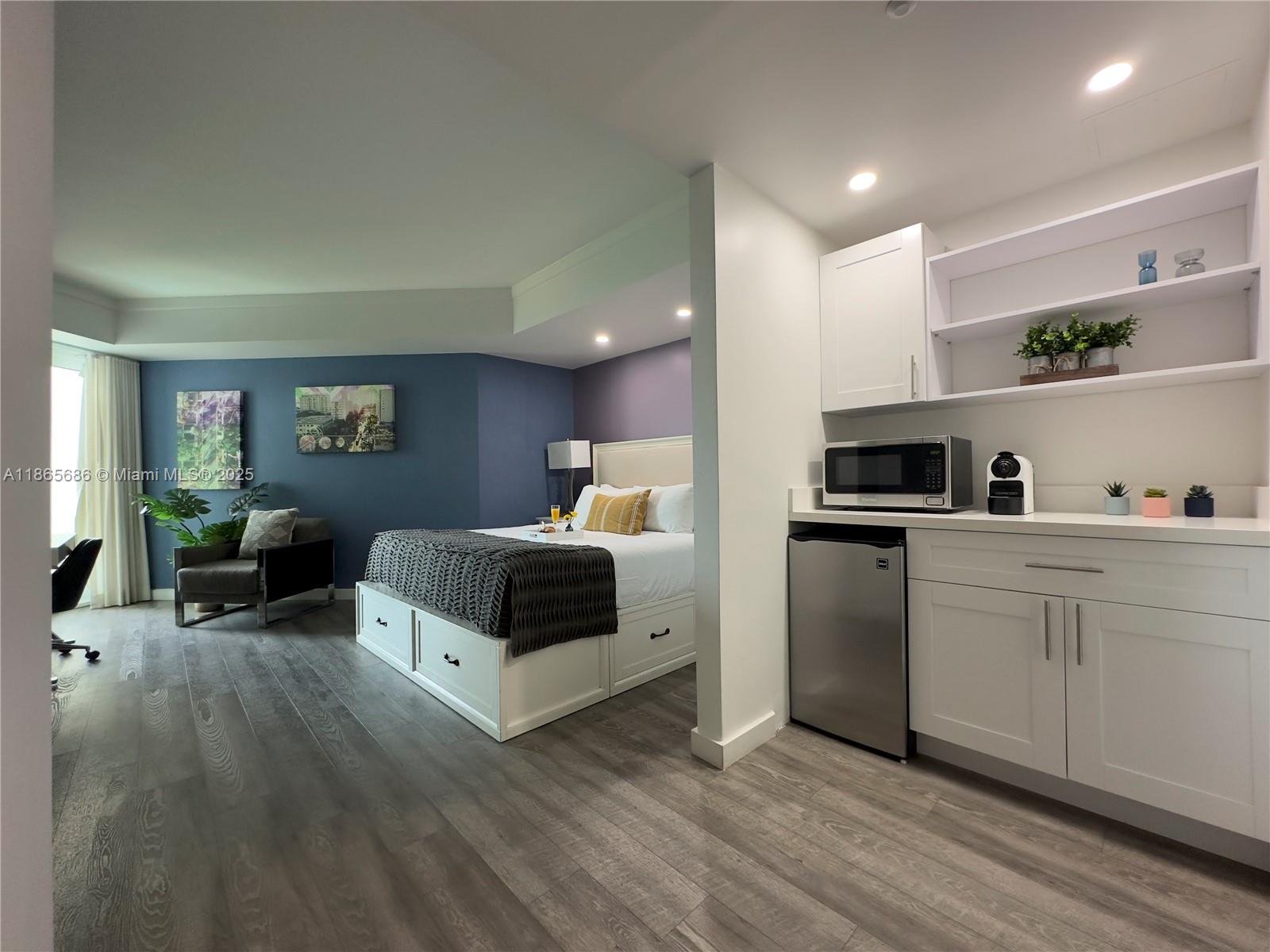 2889 McFarlane Road, Unit 1406 Miami, FL 33133 - Photo 20 of 23 a kitchen with white cabinets and stainless steel appliances