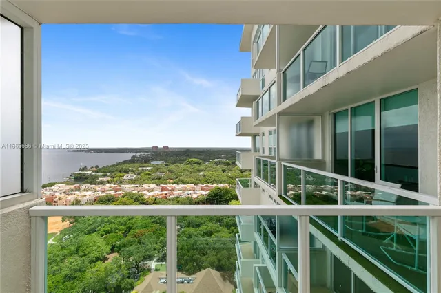 a view of a balcony with wooden floor & fence