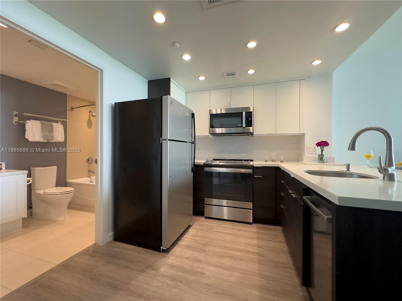 2889 McFarlane Road, Unit 1406 Miami, FL 33133 - Photo 8 of 23 a kitchen with a sink appliances and cabinets