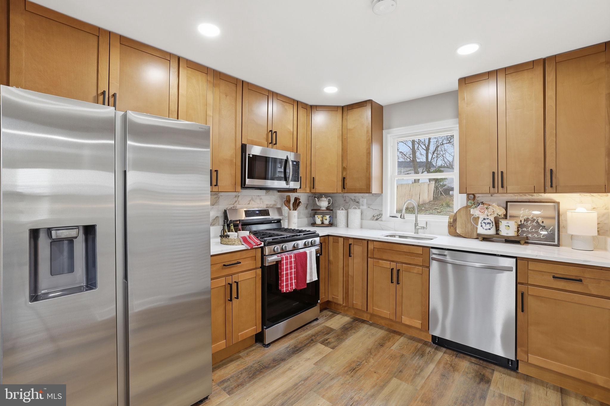 2403 Greeley Place Landover, MD 20785 - Photo 2 of 39 a kitchen with stainless steel appliances granite countertop a refrigerator a sink dishwasher a stove and white cabinets with wooden floor