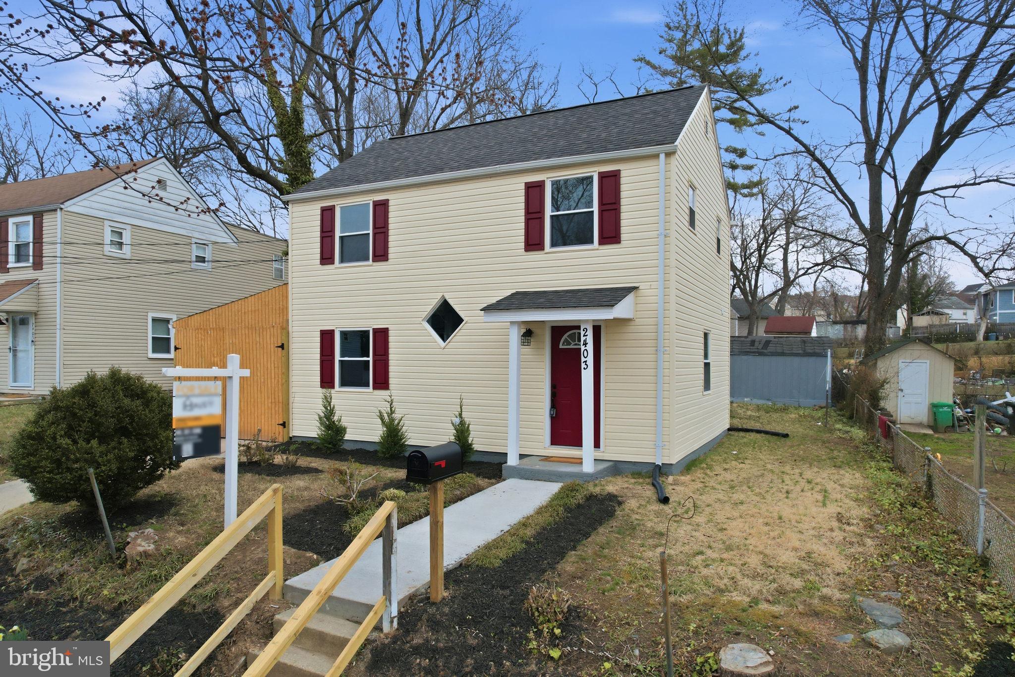 2403 Greeley Place Landover, MD 20785 - Photo 29 of 39 a view of a white house with a large tree and wooden fence