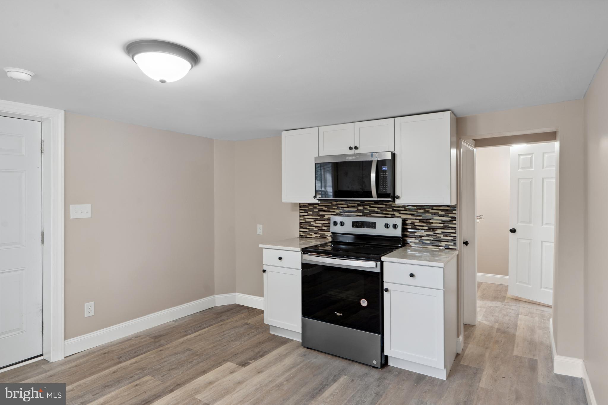918 East Commerce Street Bridgeton, NJ 08302 - Photo 11 of 30 a kitchen with a stove and a microwave
