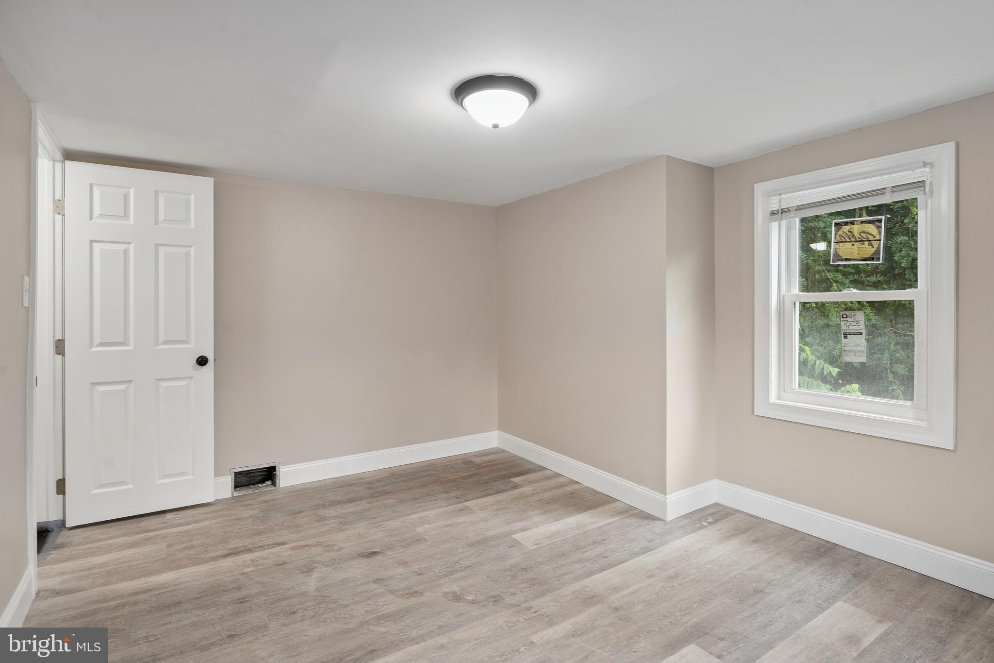918 East Commerce Street Bridgeton, NJ 08302 - Photo 23 of 30 wooden floor in an empty room with a window
