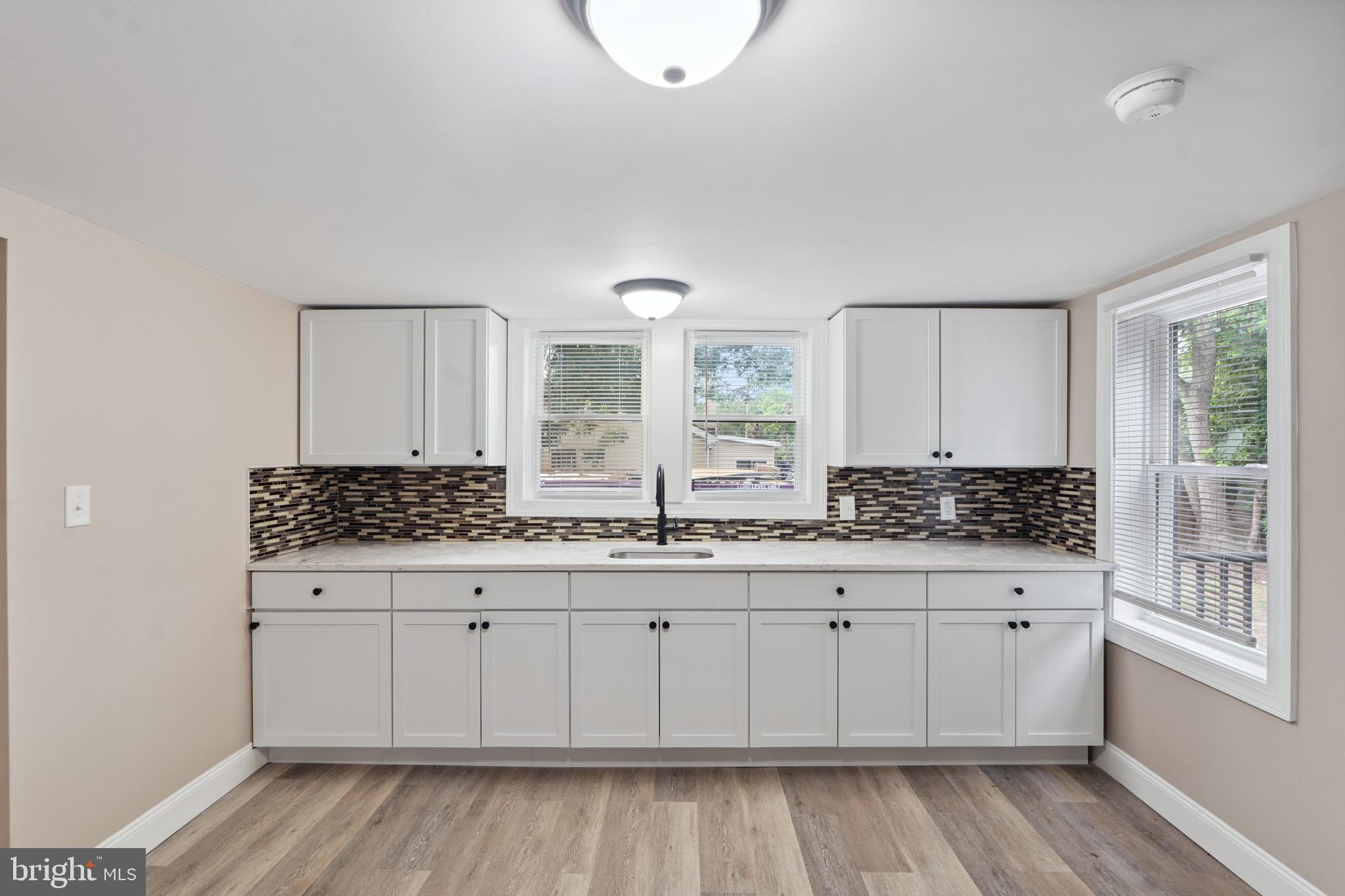 918 East Commerce Street Bridgeton, NJ 08302 - Photo 9 of 30 a kitchen with a sink a stove cabinets and wooden floor