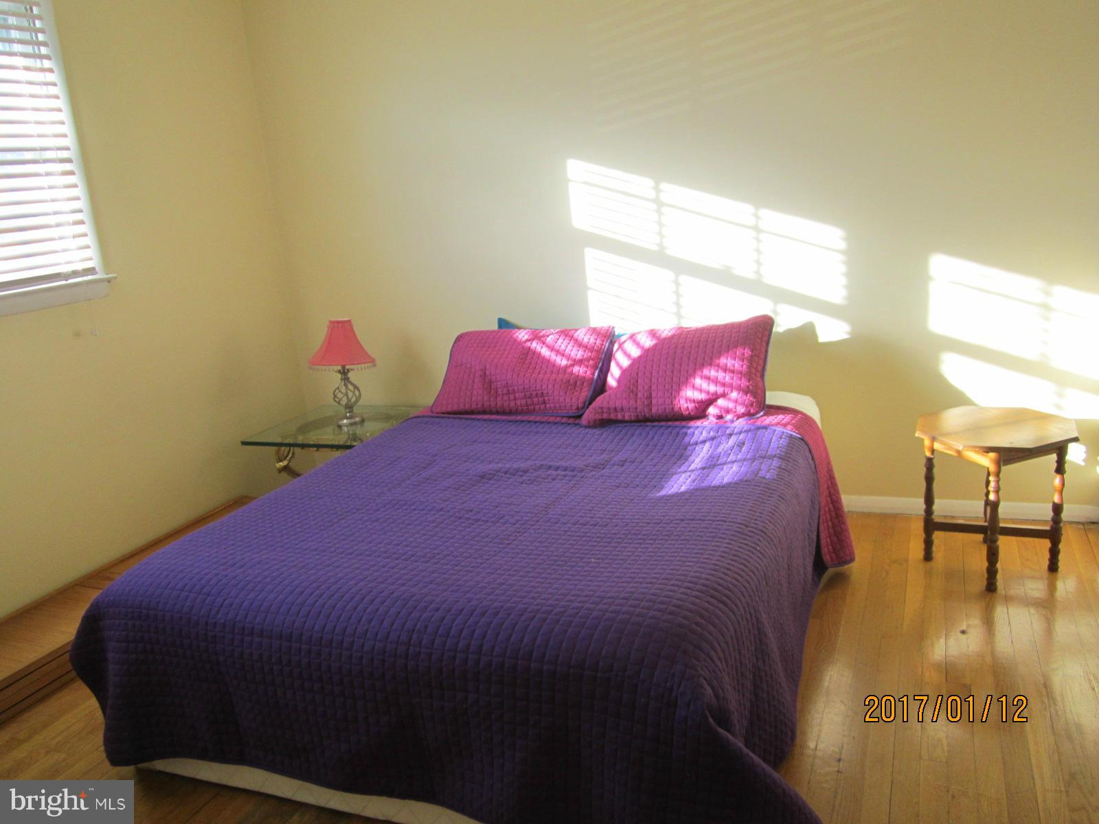 6304 Magdolena Road Baltimore, MD 21237 - Photo 19 of 26 a bed sitting in a bedroom next to a window