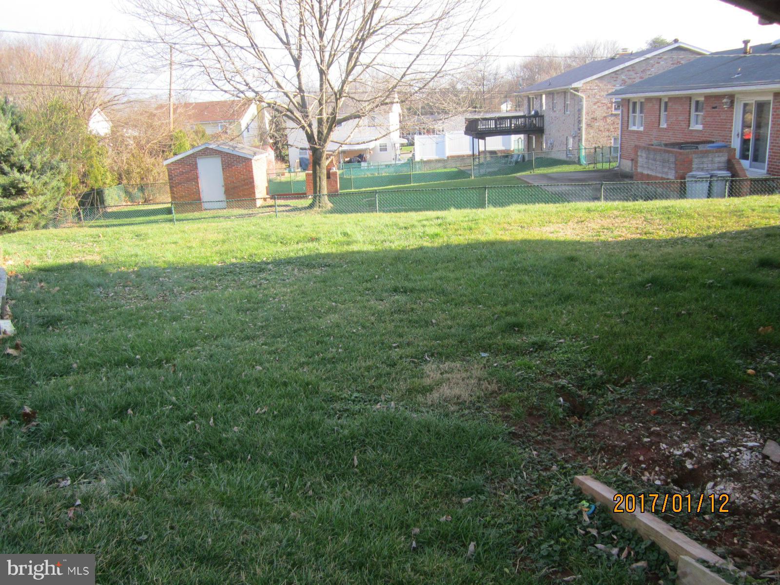 6304 Magdolena Road Baltimore, MD 21237 - Photo 5 of 26 a view of a big house with a big yard and large trees