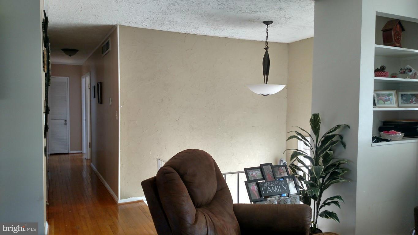 6304 Magdolena Road Baltimore, MD 21237 - Photo 6 of 26 a view of a hallway with furniture and wooden floor