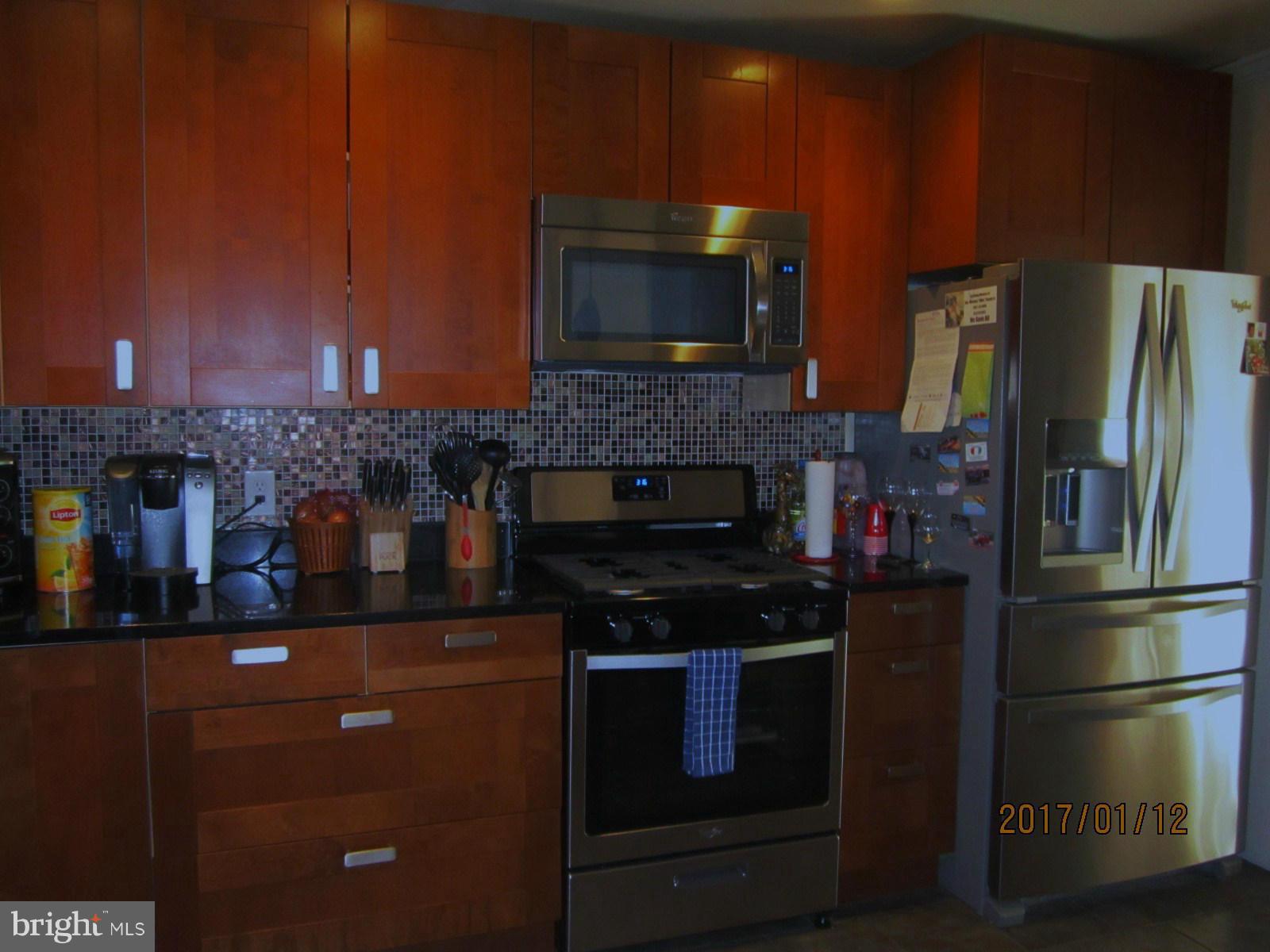 6304 Magdolena Road Baltimore, MD 21237 - Photo 9 of 26 a kitchen with stainless steel appliances a stove microwave and refrigerator