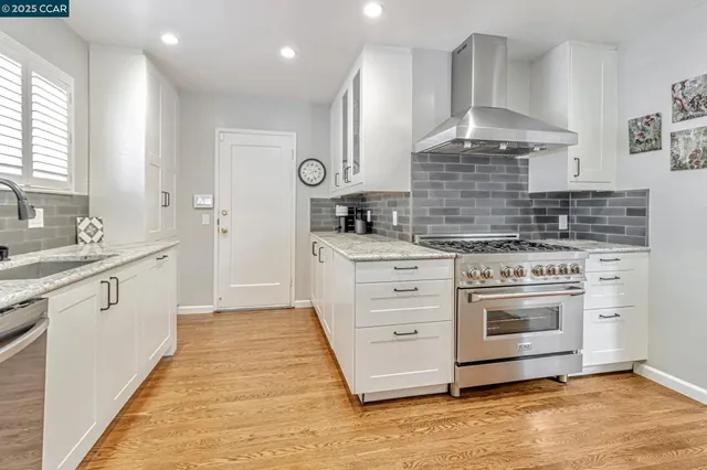 a kitchen with stainless steel appliances granite countertop a sink stove and refrigerator