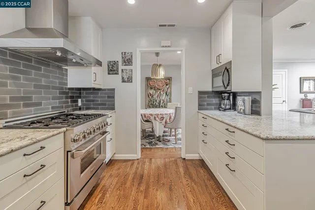 a kitchen with white cabinets and appliances