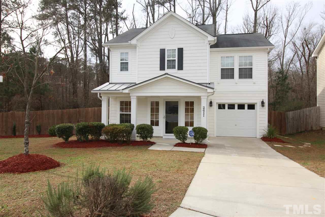 2411 Quarry Ridge Lane Raleigh, NC 27610 - Photo 1 of 22 a front view of a house with a yard and potted plants