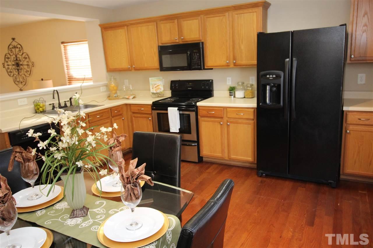 2411 Quarry Ridge Lane Raleigh, NC 27610 - Photo 9 of 22 a kitchen with stainless steel appliances wooden floors and wooden cabinets