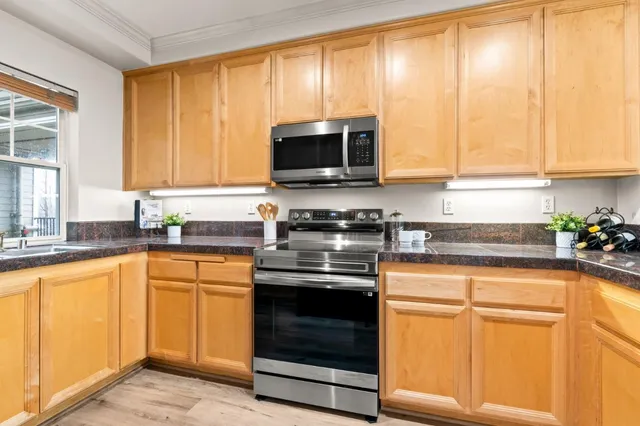 a kitchen with granite countertop a stove top oven microwave and cabinets