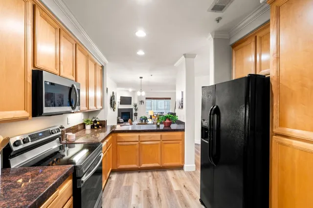 a kitchen with stainless steel appliances a refrigerator a stove a sink and a microwave