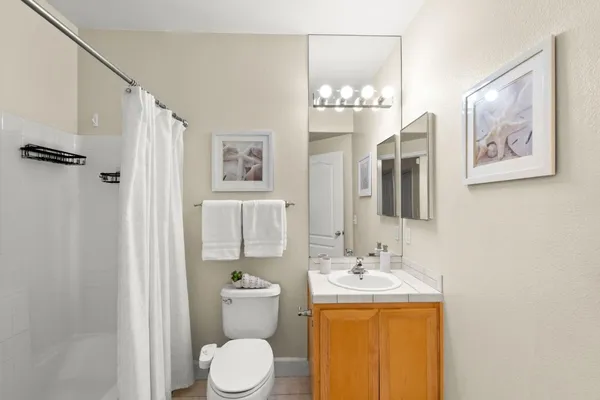 a bathroom with a granite countertop sink toilet and shower
