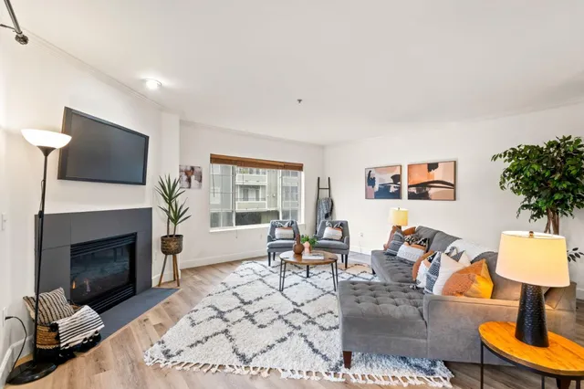 a living room with furniture a flat screen tv and a fireplace