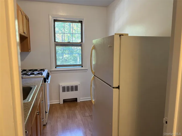 a kitchen with a refrigerator and wooden floor