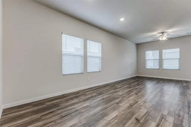a view of an empty room with a chandelier fan