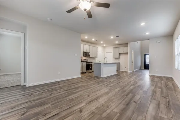 a view of kitchen with granite countertop cabinets and refrigerator
