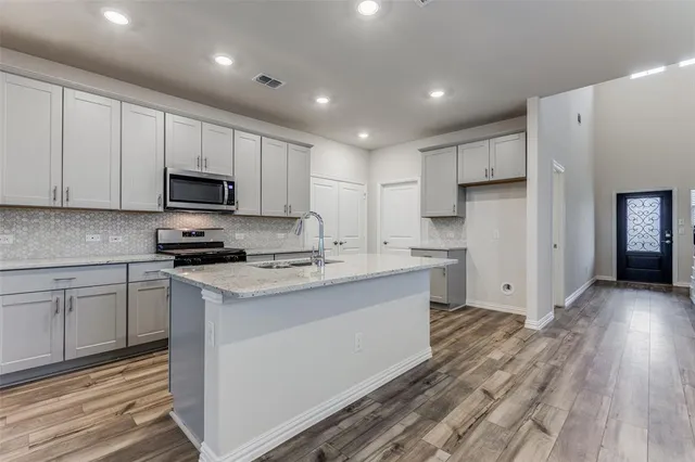 a kitchen with appliances a sink and cabinets