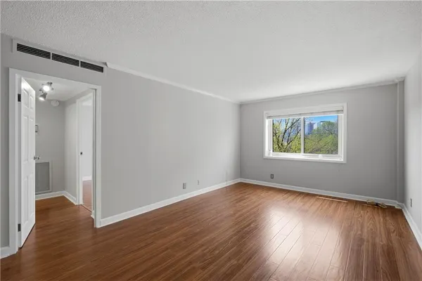 a view of an empty room with wooden floor