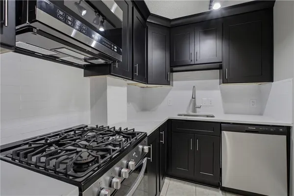 a kitchen with stainless steel appliances granite countertop a refrigerator and a stove