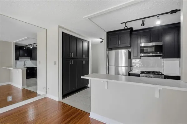 a view of a kitchen with wooden floor and a refrigerator