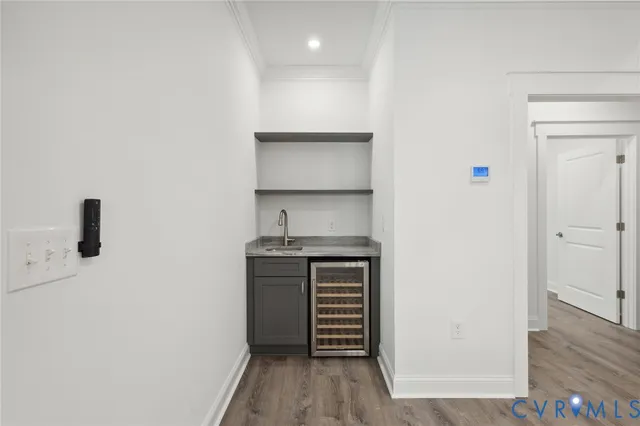 an empty room with wooden floor cabinet and windows