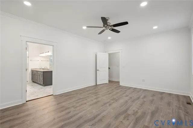 a view of an empty room with wooden floor and a large window