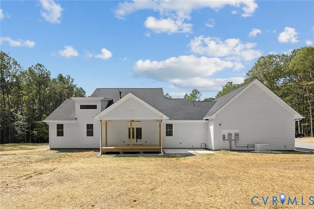 an empty room with wooden floor a fireplace and windows