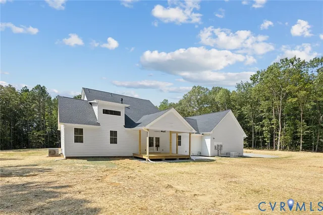 an empty room with wooden floor chandelier and windows