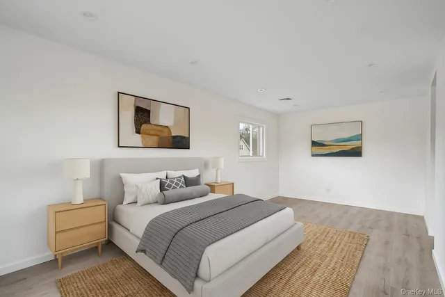 a bedroom with a bed and a painting on the wall