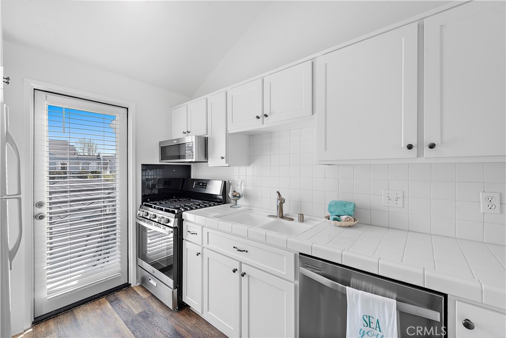 24451 Lantern Hill Drive, Unit D Dana Point, CA 92629 - Photo 8 of 32 a kitchen with granite countertop white cabinets and white appliances