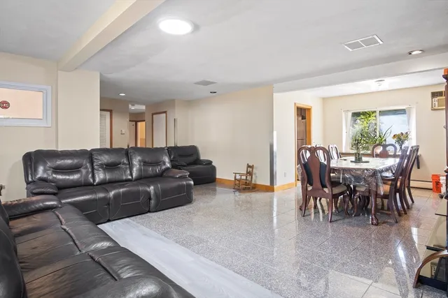 a living room with furniture and a dining table