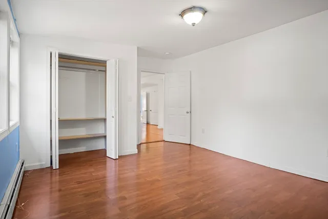 an empty room with wooden floor & closet