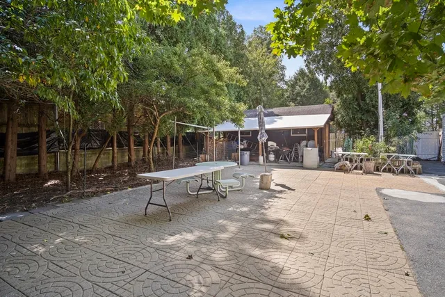 a backyard of a house with fountain table and chairs