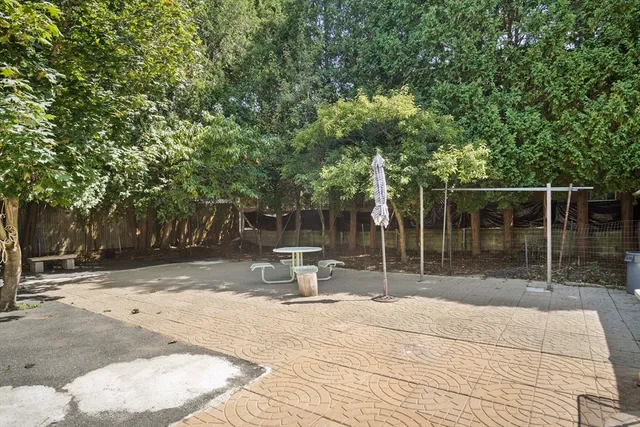 a view of a white house with large windows and a tree