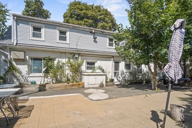 a view of a patio with a table and chairs under an umbrella