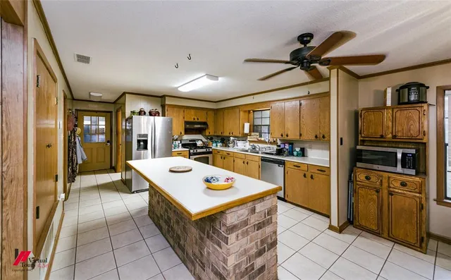 a kitchen with granite countertop a refrigerator stove top oven and sink
