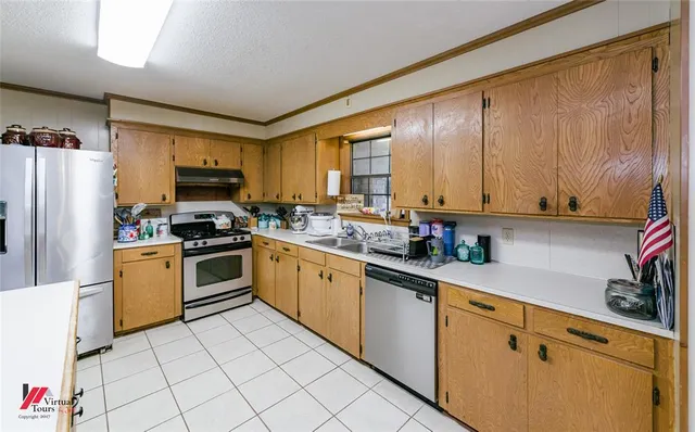 a kitchen with a stove a refrigerator and a sink