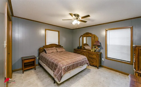 a bedroom with a bed and a flat tv screen on dresser