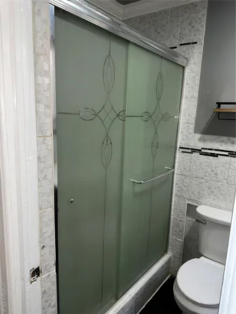 a bathroom with a granite countertop toilet and a shower