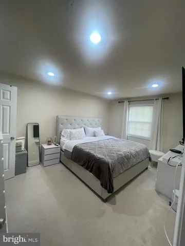 a spacious bedroom with a bed and a lamp