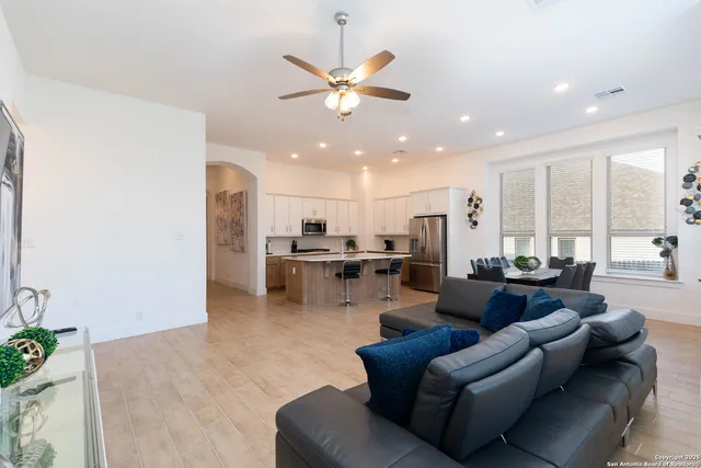 a living room with furniture kitchen view and a chandelier