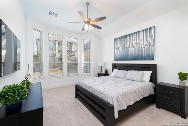 a bed sitting in a spacious bedroom next to a window